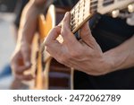 Close-up of a musician’s hands playing an acoustic guitar. Passion and skill of a guitarist, highlighting the beauty of musical expression. Perfect for themes of music, creativity, and talent.