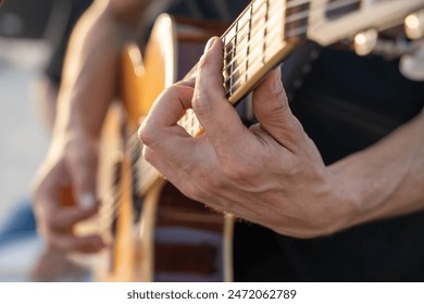 Close-up of a musician’s hands playing an acoustic guitar. Passion and skill of a guitarist, highlighting the beauty of musical expression. Perfect for themes of music, creativity, and talent. - Powered by Shutterstock