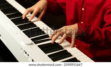 Close-up of hands playing a white digital piano, fingers pressing keys. Practice piano at home. Concept of education, teaching, learning and friendship.