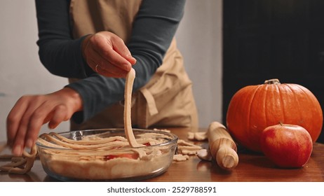 Close-up hands preparing homemade pie with fresh pumpkin and apple ingredients - Powered by Shutterstock