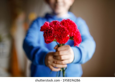 Closeup Of Hands Of Preteen Kid Boy Holding Bunch Of Clove Flowers. Child Congrats And Presents Cloves To Mother Or Girl Friend For Mothers Day Or Valentines Day.