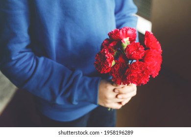 Closeup Of Hands Of Preteen Kid Boy Holding Bunch Of Clove Flowers. Child Congrats And Presents Cloves To Mother Or Girl Friend For Mothers Day Or Valentines Day.