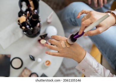 Closeup hands professional makeup artist applying liquid foundation mixing colors top view. Make up master testing cosmetics skin tone complexion texture preparing to visage at beauty salon