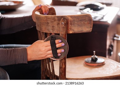 Closeup of hands removing old paint layer sanding surface of antique chair with special sandpaper in home workshop. Sustainable practices. Reuse of old things. Recycle. - Shutterstock ID 2138916263