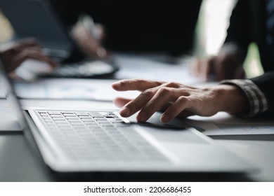 Close-up Of Hands Resting On Keyboard To View Financial Data, Business Growth In The World Of Cryptocurrencies And The Current Global Economy With War And Volatility. Finance And Investment Concepts.