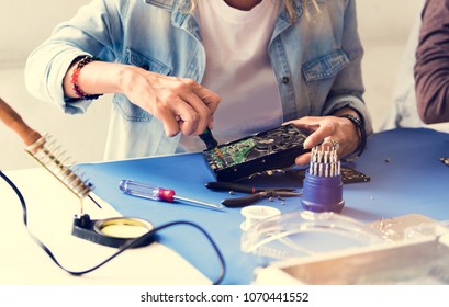 Closeup of hands with screwdriver with computer hard disk - Shutterstock ID 1070441552