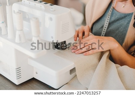 Close-up of the hands of a seamstress who sews curtains on a sewing machine