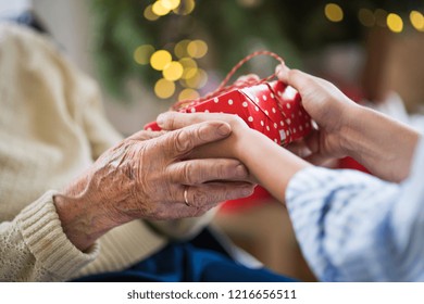 Close-up of hands of senior and young woman holding a present at Christmas. - Powered by Shutterstock