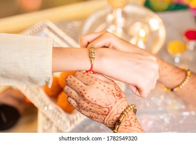 Closeup Of Hands, Sister Tying Rakhi, Raksha Bandhan To Brother's Wrist During Festival Or Ceremony - Rakshabandhan Celebrated Across India As Selfless Love Or Relationship Between Brother And Sister