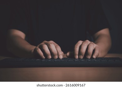 Close-up of hands typing on a keyboard in a dark room, representing cybersecurity, hacking, or late-night programming.