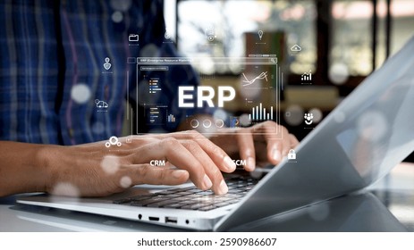 Close-up of hands typing on a laptop keyboard with a futuristic digital interface displaying ERP (Enterprise Resource Planning) system, analytics, and business management icons.
