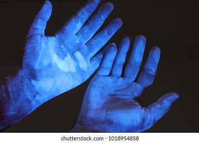 Closeup Of Hands Under Black Light To Detect Germs