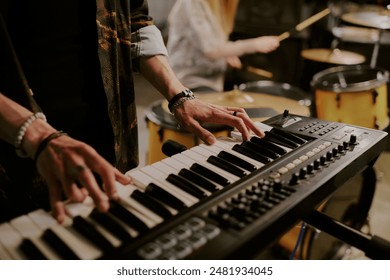 Closeup of hands of unrecognizable male musician playing synthesizer in rock band - Powered by Shutterstock