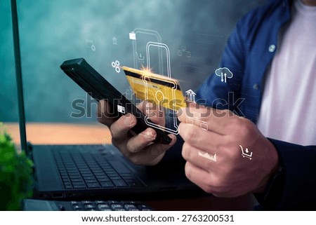 Close-up of hands using a smartphone and credit card above a laptop with a digital lock overlay, illustrating secure online payment, fintech protection, ecommerce checkout, and mobile banking.