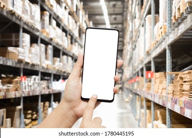 Close-up Hands Using Smartphone In Warehouse Industry Blur Background For Logistic Wholesale Storehouse, Online Shopping Concept. Mockup Blank White Screen Mobile Phone With Blur Warehouse.