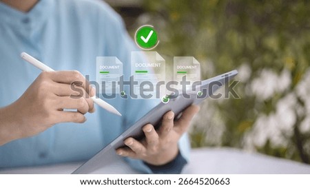 Close-up of hands using stylus on tablet to sign and approve digital documents, concept of paperless workflow and e-signature.
