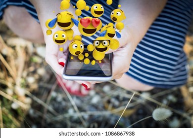 Close-up of a hands of a woman chatting and using emojis. All screen graphics are made up. - Powered by Shutterstock