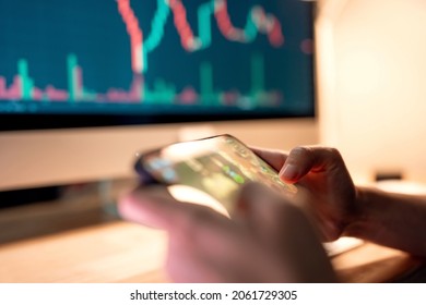 Close-up - Hands of woman playing blockchain nft game in mobile phone on price chart digital exchange background, Play to earn cryptocurrency rewards.