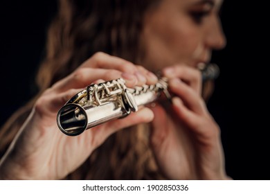 Close-up of the hands of a woman playing the flute. Musical concept