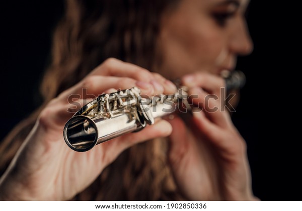 Close-up of the hands of a woman playing the
flute. Musical concept