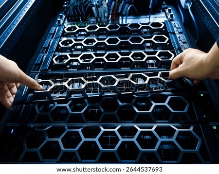 A close-up of hands working on a server rack in a modern data center, showcasing detailed hardware components and organized wiring for optimal performance.