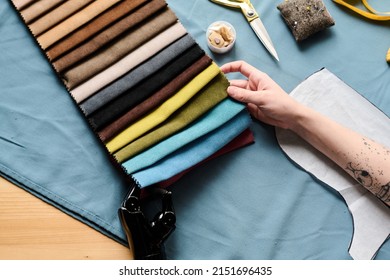 Close-up Of Hands Of Young Woman With Disability Choosing Fabric Color