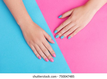 Closeup Of Hands Of A Young Woman With Manicure On Nails Against Pink Background
