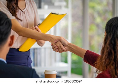 Closeup handshake when interview between Young Asian woman and two manager with positive motion in meeting room,Business Hiring new member concept