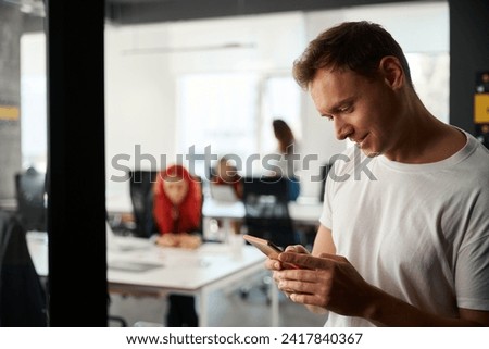 Close-up handsome young man playing games on smartphone instead of work