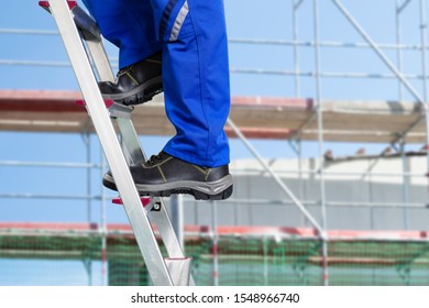 Close  up Of A Handy Repair Man Standing On Steel Ladder Against Construction Sites