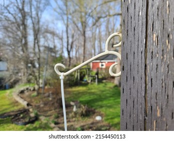 A Closeup Of A Hanger Attached To A Pole With An Old White Zip Tie Attached To It.