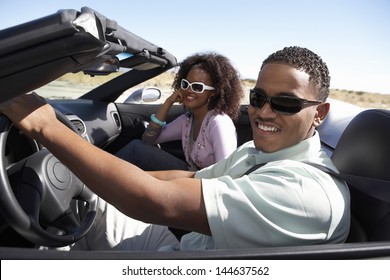 Closeup of a happy African American couple driving convertible on desert road