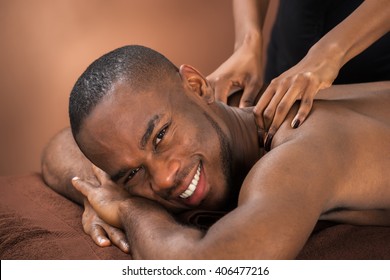 Close-up Of Happy African Man Receiving Massage Treatment