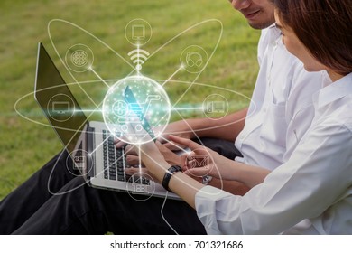 Closeup Happy Asian Couple College Working Via Technology Smart Mobile Phone And Laptop For Online Shopping With Omni Channel In The Park, Lifestyle And Technology Concept