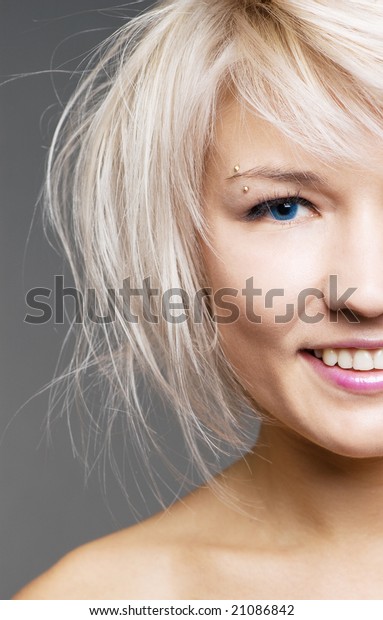 closeup of happy blond with blue eyes over\
grey background