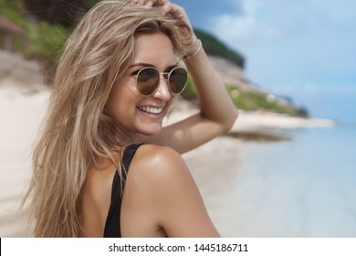 Close-up happy carefree woman walking sandy beach near ocean turn behind smile camera touch hair wear sunglasses enjoy awesome summer vacation, wanna swim, like seaside view, travelling - Powered by Shutterstock