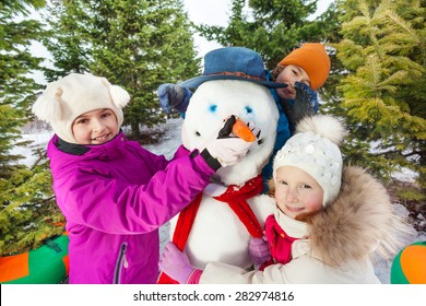 Close-up Of Happy Children Build Cheerful Snowman