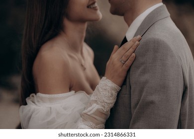 Closeup of happy couple having photoshoot outdoors, kissing. Young groom and bride getting married, smiling, enjoying, having photoshoot. Concept of happiness and family relations. - Powered by Shutterstock