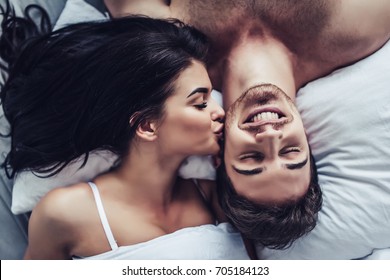 Close-up of happy couple is lying in bed together. Enjoying the company of each other.