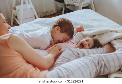 Closeup of happy family playing over the bed in a relaxed morning. Weekend family leisure time concept. - Powered by Shutterstock