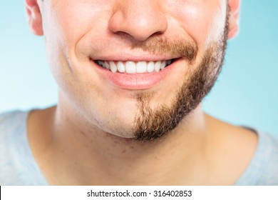 Closeup Of Happy Man With Half Shaved Face Beard Hair. Smiling Guy On Blue. Skin Care And Hygiene.