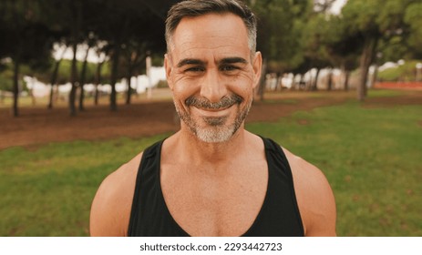 Close-up happy mature muscular man in sportswear looking at camera and smiling - Shutterstock ID 2293442723