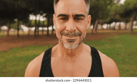 Close-up happy mature muscular man in sportswear looking at camera and smiling - Shutterstock ID 2296443011