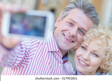 Close-up Of Happy Middle-aged Couple Taking Selfie Through Smart Phone