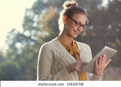 closeup of happy woman in glasses using tablet pc in the park - Powered by Shutterstock