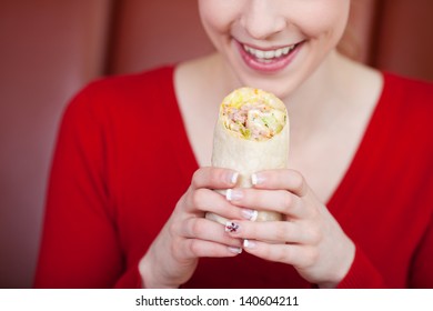 Closeup Of Happy Woman Holding Wrap In Coffee Shop