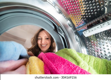 Close-up Of Happy Woman View From Inside The Washer With Clothes