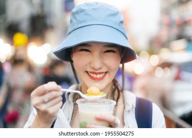 Closeup Happy Young Adult Asian Foodie Woman Backpack Traveller Eating Asia Dessert. People Traveling With Lifestyle Outdoor At China Town Street Food Market. Bangkok, Thailand