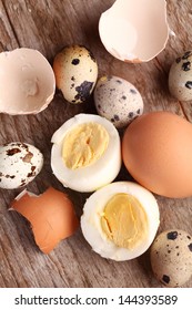 Close-up of hard boiled egg, egg shells and quail eggs.