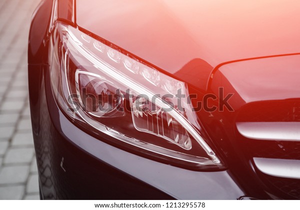 Closeup\
headlight luxury sedan car lighting\
road.